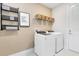 Functional laundry room with modern appliances, storage shelves, and stylish decor at 3814 Blue Vale Dr, Davenport, FL 33837