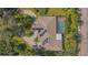 Aerial view of a large property featuring a pool, solar panels, and a circular driveway surrounded by lush greenery at 4735 Chelsea Ct, Kissimmee, FL 34744