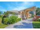 Inviting single-story home featuring a columned front porch, colorful bushes, and a long driveway at 4735 Chelsea Ct, Kissimmee, FL 34744