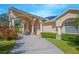 Inviting single-story home with a columned entrance and colorful bushes enhancing its curb appeal on a sunny day at 4735 Chelsea Ct, Kissimmee, FL 34744