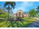 Charming single Gathering home with lush landscaping, mature trees, and a welcoming front entrance under a sunny blue sky at 4735 Chelsea Ct, Kissimmee, FL 34744