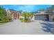 Spacious home with a wide driveway leading to a large garage, complemented by solar panels and landscaped features at 4735 Chelsea Ct, Kissimmee, FL 34744
