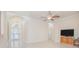 Open living room with tile floors, chandelier, arched entryways and television at 4735 Chelsea Ct, Kissimmee, FL 34744