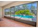 View of the pool from screened-in patio, with mature trees and landscaping at 4735 Chelsea Ct, Kissimmee, FL 34744