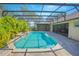 Beautiful view of screened-in pool surrounded by brick pavers and tropical foliage at 4735 Chelsea Ct, Kissimmee, FL 34744