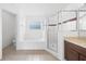 Bright bathroom featuring a tub, glass shower, and a granite counter vanity at 4785 Cumbrian Lakes Dr, Kissimmee, FL 34746