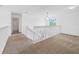 Carpeted landing area with white railings, a window, and access to the upstairs at 4785 Cumbrian Lakes Dr, Kissimmee, FL 34746