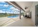 Screened-in pool and patio area with water views, dining area and ceiling fan at 4785 Cumbrian Lakes Dr, Kissimmee, FL 34746