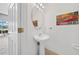 Cozy powder room with a pedestal sink, decorative mirror, and inspirational wall art at 4785 Cumbrian Lakes Dr, Kissimmee, FL 34746