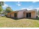 Home's backyard featuring a well-maintained lawn and the exterior of the house with sliding glass doors at 4806 Gallant Ln, Orlando, FL 32821