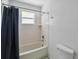 Simple bathroom featuring a shower-tub combination with tiled walls and a window providing natural light at 4806 Gallant Ln, Orlando, FL 32821