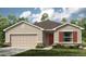 Charming single-story home with a two-car garage, lush landscaping, and a welcoming front entrance at 4859 Sunflower St, Lake Hamilton, FL 33851