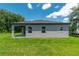 Exterior back view of the home showcasing the patio, windows, and grassy backyard at 506 Marion Oaks Trl, Ocala, FL 34473