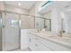 Bathroom featuring a glass shower, double sinks, and quartz countertops at 506 Marion Oaks Trl, Ocala, FL 34473