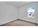 Bright bedroom with plush carpeting and a window offering outdoor views at 506 Marion Oaks Trl, Ocala, FL 34473
