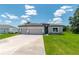 Charming single-story home featuring a three-car garage and neutral gray stucco exterior with stone accents at 506 Marion Oaks Trl, Ocala, FL 34473