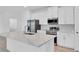 Close up of kitchen with stainless steel appliances, island and white cabinets at 506 Marion Oaks Trl, Ocala, FL 34473