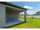 Outdoor patio with grey concrete, lush lawn, and a partial view of neighboring homes at 506 Marion Oaks Trl, Ocala, FL 34473