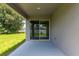 Outdoor patio with sliding glass doors and a view of the green lawn at 506 Marion Oaks Trl, Ocala, FL 34473