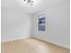 A minimalist bedroom with light wood flooring and a view to the backyard at 5116 Sorrento W Blvd, St Cloud, FL 34771