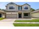 Charming two-story home with a manicured lawn, attached two-car garage, and inviting front porch at 5116 Sorrento W Blvd, St Cloud, FL 34771