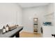 Well-equipped laundry room features counter space, storage shelves, and a modern washing machine at 5116 Sorrento W Blvd, St Cloud, FL 34771