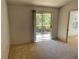 Sunlit bedroom featuring neutral carpeting and a sliding glass door leading to a balcony at 5291 Images Cir # 301, Kissimmee, FL 34746