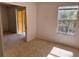 Bright bedroom with tan carpet, window, and sliding glass door to the outside at 5291 Images Cir # 301, Kissimmee, FL 34746