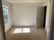 The bedroom has tan carpet, a window, and a closet for clothing storage at 5291 Images Cir # 301, Kissimmee, FL 34746