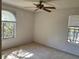 Bedroom features carpet, two windows with blinds, and a ceiling fan at 5291 Images Cir # 301, Kissimmee, FL 34746