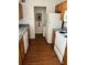 Functional kitchen with wooden cabinets, white appliances, and vinyl flooring at 5291 Images Cir # 301, Kissimmee, FL 34746