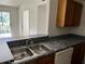 Galley kitchen featuring stone countertops and stainless steel sink at 5291 Images Cir # 301, Kissimmee, FL 34746