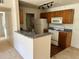 Cozy kitchen featuring wooden cabinets, white appliances, and a breakfast bar at 5291 Images Cir # 301, Kissimmee, FL 34746