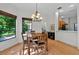 A dining room features hardwood floors, a chandelier, and views into the kitchen at 602 Nighthawk Cir, Winter Springs, FL 32708