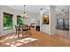 A dining room features wood floors, a chandelier, large windows, and an open view into the kitchen at 602 Nighthawk Cir, Winter Springs, FL 32708