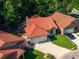 Aerial view of the home's exterior, landscaped yard, and red tile roof at 602 Nighthawk Cir, Winter Springs, FL 32708