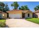 Charming single-story home with a red tile roof, well-manicured lawn, and a two-car garage at 602 Nighthawk Cir, Winter Springs, FL 32708