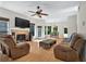 Open-concept living room with a fireplace, large windows, and a ceiling fan at 602 Nighthawk Cir, Winter Springs, FL 32708