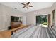 Spacious bedroom with hardwood floors, ceiling fan, dresser, TV, and sliding glass door at 602 Nighthawk Cir, Winter Springs, FL 32708