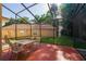 Screened patio with table and chairs, backyard with lush trees at 602 Nighthawk Cir, Winter Springs, FL 32708