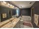 This bathroom boasts a tiled deck tub, a toilet and vanity with marble countertops, and a shower at 6436 Fig Leaf St, Magnolia Square, FL 34771