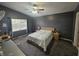 This bedroom has a ceiling fan, one window, a desk and a bed with a floral patterned quilt at 6436 Fig Leaf St, Magnolia Square, FL 34771