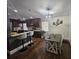 Modern kitchen featuring dark wood cabinets, white countertops, stainless steel appliances, and a dining table at 6436 Fig Leaf St, Magnolia Square, FL 34771