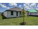 Backyard with a young tree and view of the home's exterior at 706 Junonia Blvd, New Smyrna Beach, FL 32168