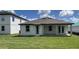 Home with spacious backyard, featuring a covered patio and lush lawn at 706 Junonia Blvd, New Smyrna Beach, FL 32168
