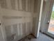 Unfinished bathroom showing drywall and plumbing, ready for customization, with a view to the outside at 706 Junonia Blvd, New Smyrna Beach, FL 32168