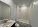 Modern bathroom showcasing a shower/tub combo and a sink with a dark wood cabinet at 706 Junonia Blvd, New Smyrna Beach, FL 32168