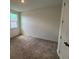Bright carpeted bedroom with natural light from window and an overhead light at 706 Junonia Blvd, New Smyrna Beach, FL 32168