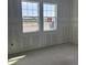 Unfinished bedroom features a concrete floor and two windows at 706 Junonia Blvd, New Smyrna Beach, FL 32168