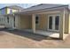 An inviting covered patio with support beams and double glass doors leading to a home's interior at 706 Junonia Blvd, New Smyrna Beach, FL 32168